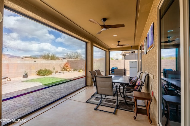 view of patio featuring outdoor dining area, a fenced backyard, and a ceiling fan