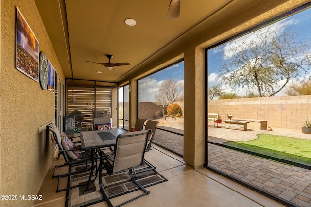 sunroom / solarium with a ceiling fan