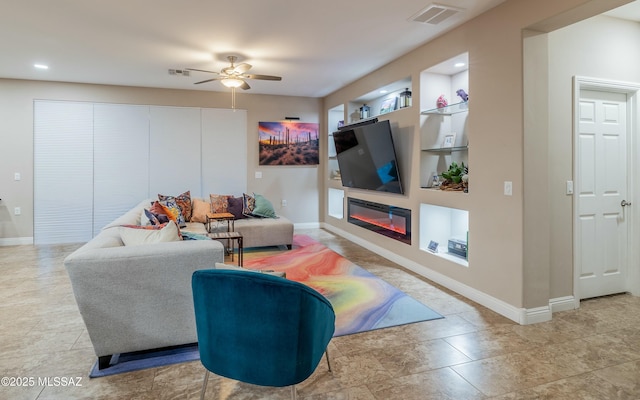 living room featuring built in shelves, a glass covered fireplace, visible vents, and baseboards