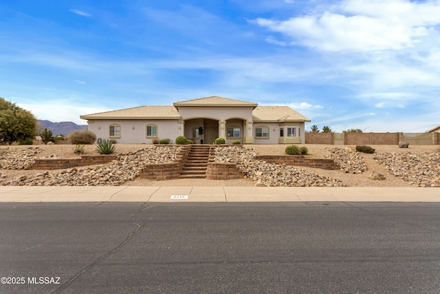 view of front of property featuring fence and stucco siding