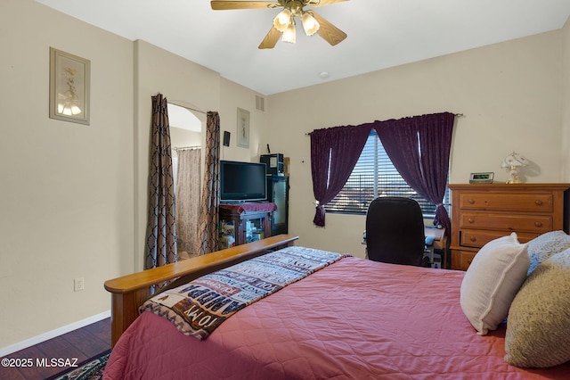 bedroom with visible vents, a ceiling fan, baseboards, and wood finished floors