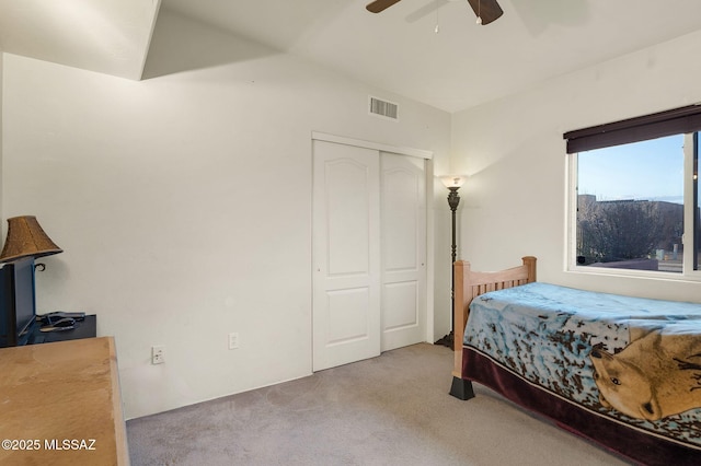 bedroom with a closet, visible vents, ceiling fan, and carpet