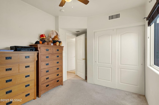 bedroom featuring visible vents, light colored carpet, and a closet