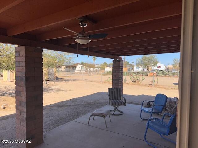 view of patio featuring a ceiling fan and fence