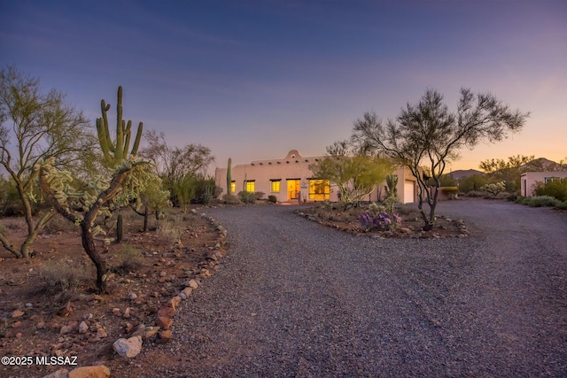 pueblo-style house featuring driveway and an attached garage