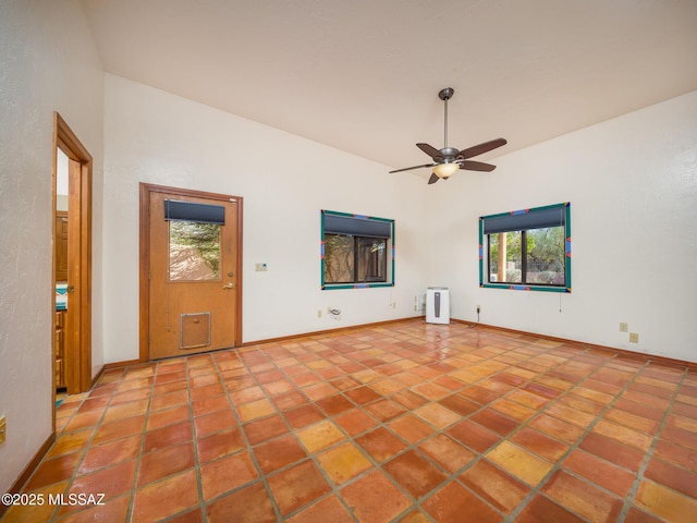 tiled spare room with baseboards and ceiling fan