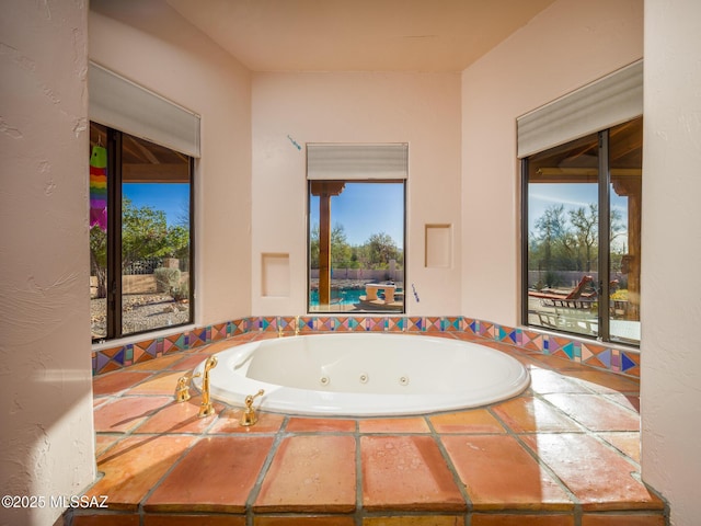 bathroom with a jetted tub and plenty of natural light