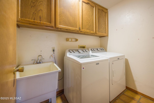 clothes washing area with separate washer and dryer, cabinet space, baseboards, and a sink