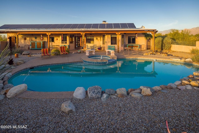 view of swimming pool featuring a patio area, a pool with connected hot tub, and a fenced backyard