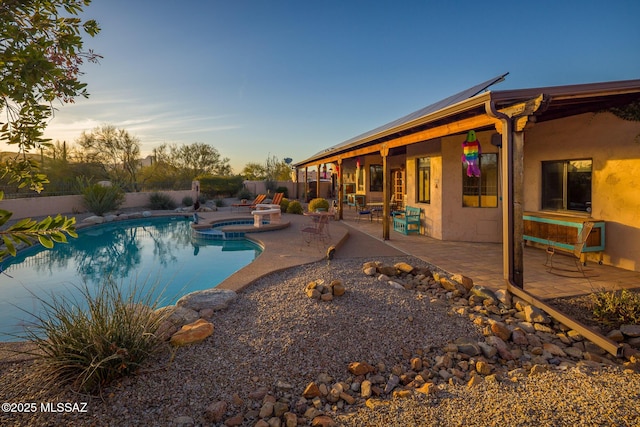 view of pool featuring a patio, a fenced backyard, and a pool with connected hot tub