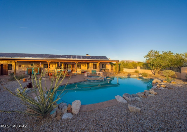 view of pool featuring a patio, a fenced backyard, and a pool with connected hot tub