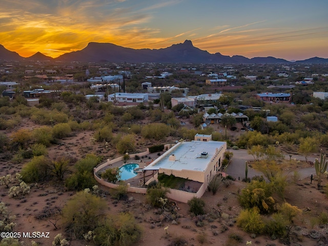 aerial view at dusk featuring a mountain view