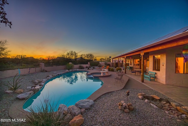 view of pool featuring a patio area, a pool with connected hot tub, and a fenced backyard