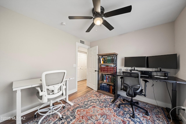 office featuring visible vents, baseboards, wood finished floors, and a ceiling fan