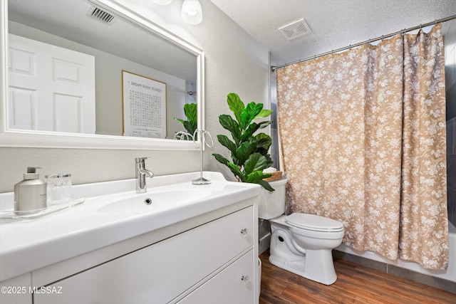 full bath featuring visible vents, toilet, vanity, and wood finished floors