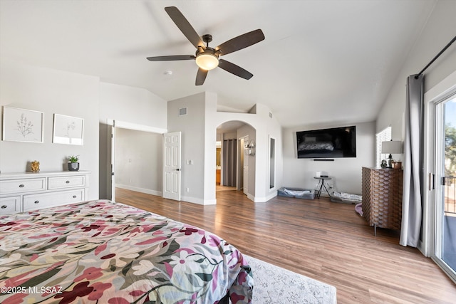 bedroom featuring visible vents, lofted ceiling, light wood-style floors, arched walkways, and access to outside