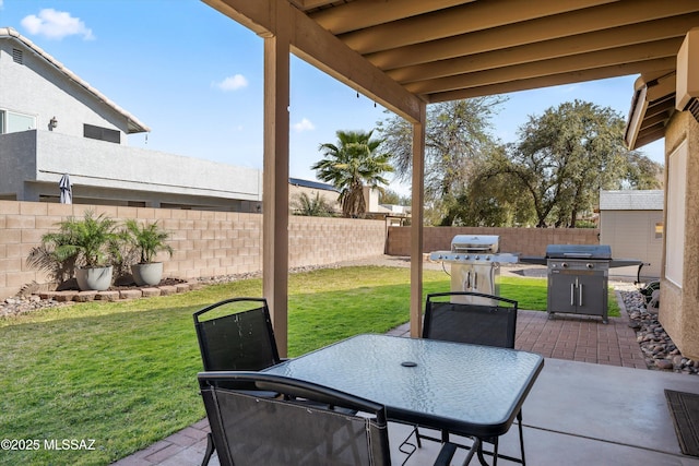 view of patio featuring outdoor dining space, area for grilling, and a fenced backyard