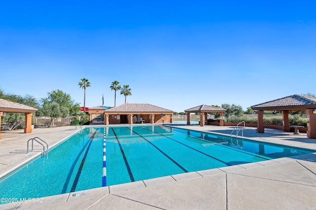 community pool with a gazebo, a patio, and fence