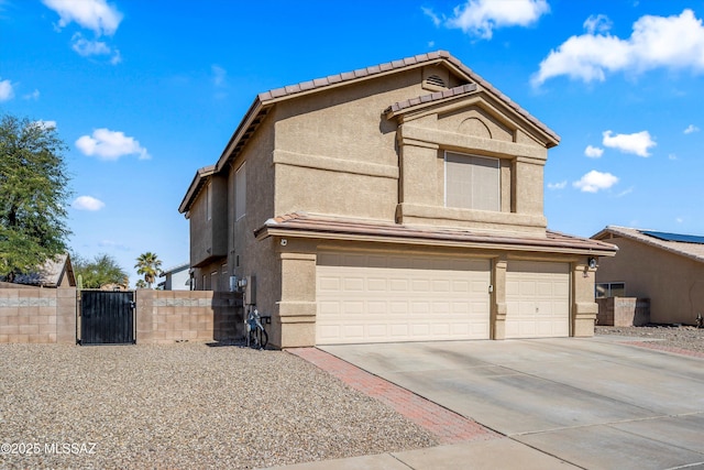 traditional home featuring a tiled roof, concrete driveway, stucco siding, an attached garage, and a gate