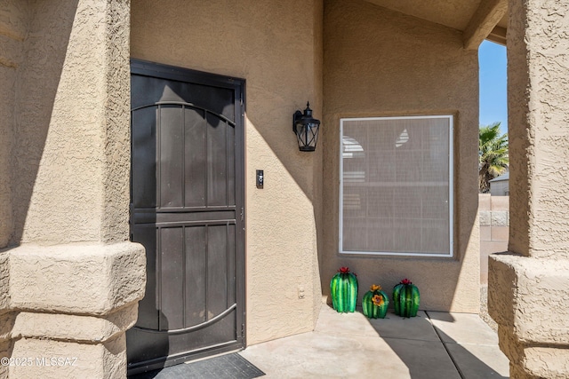 entrance to property featuring stucco siding