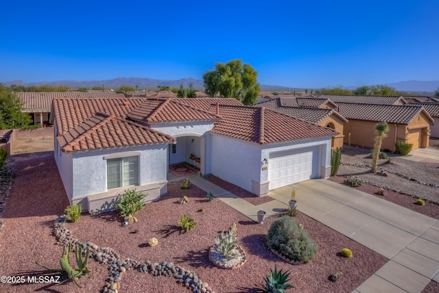 mediterranean / spanish-style house featuring concrete driveway, a tile roof, and stucco siding