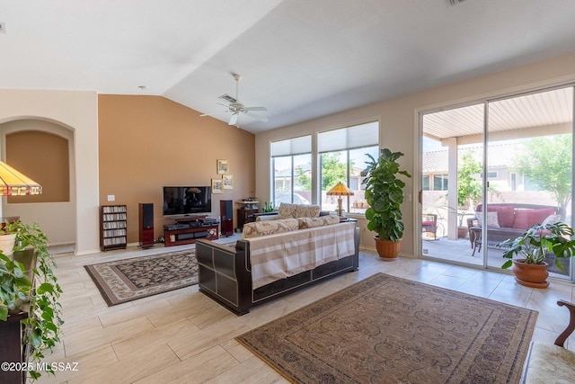 living area with lofted ceiling, a wealth of natural light, and a ceiling fan