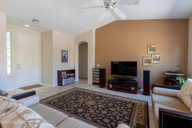 tiled living room featuring a ceiling fan, arched walkways, visible vents, and vaulted ceiling