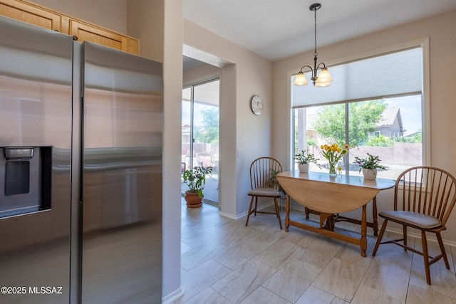 dining area with an inviting chandelier, baseboards, and a wealth of natural light