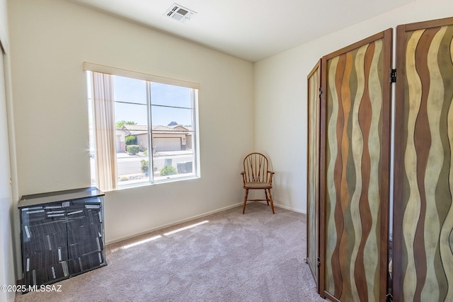 unfurnished room featuring carpet floors, visible vents, and baseboards