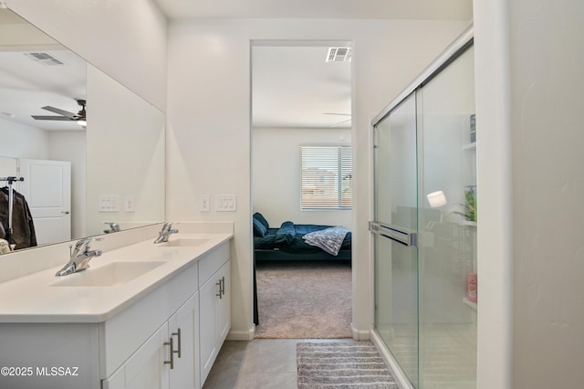 bathroom with double vanity, a shower stall, visible vents, and a sink