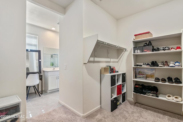 walk in closet with light carpet