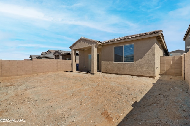 exterior space featuring a fenced backyard and stucco siding