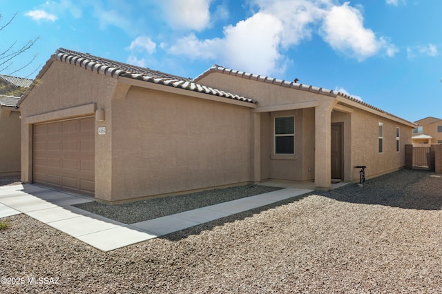 view of home's exterior featuring a garage, fence, and stucco siding