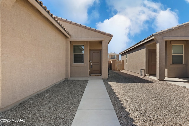 entrance to property featuring stucco siding