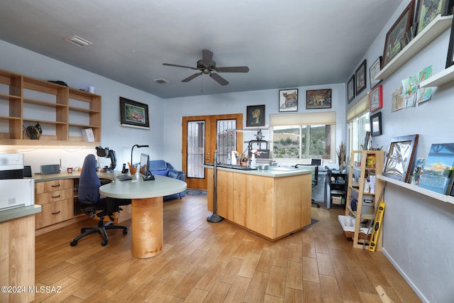 home office with a ceiling fan, visible vents, and light wood finished floors