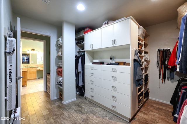 walk in closet with wood finished floors