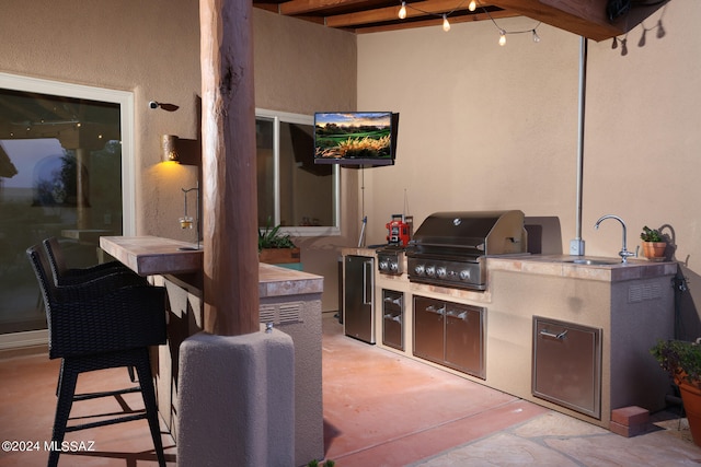 view of patio with a grill, an outdoor kitchen, and a sink