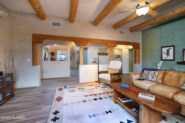 living room featuring arched walkways, visible vents, ceiling fan, wood finished floors, and beamed ceiling