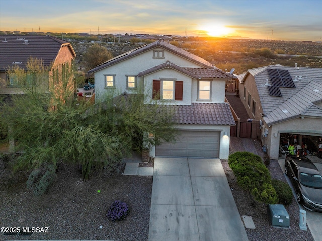 view of front of home with stucco siding, a tiled roof, and concrete driveway