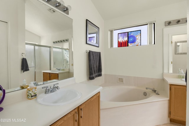 full bath with a stall shower, visible vents, two vanities, a sink, and a bath