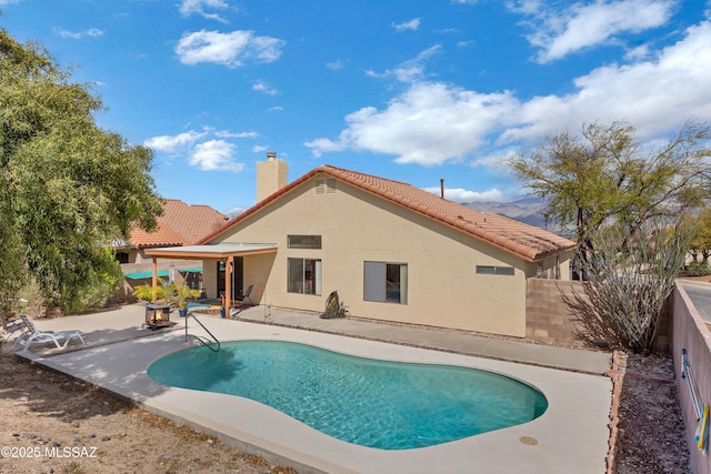 outdoor pool with a fenced backyard and a patio