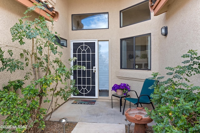 doorway to property featuring a patio area and stucco siding