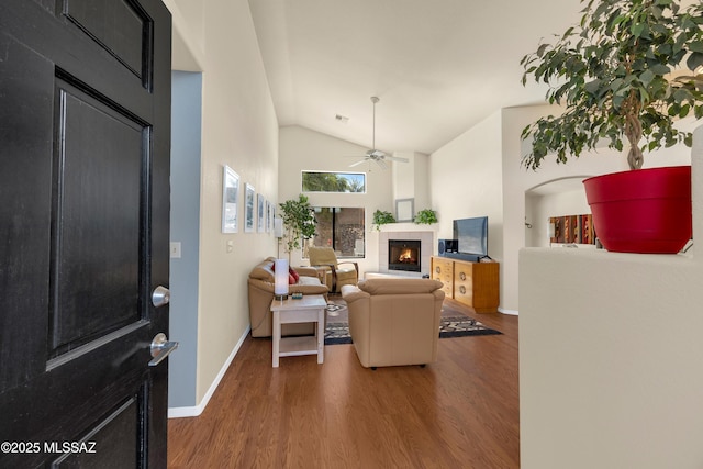 living room featuring visible vents, lofted ceiling, ceiling fan, wood finished floors, and a fireplace