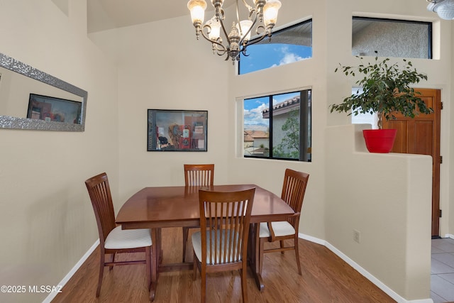 dining area featuring a chandelier, baseboards, and wood finished floors