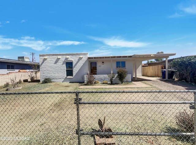 view of front of home with a fenced front yard and an attached carport