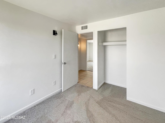 unfurnished bedroom featuring a closet, visible vents, baseboards, and carpet flooring