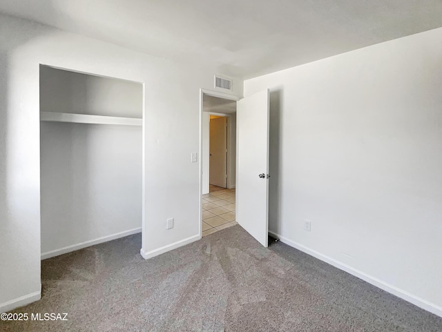 unfurnished bedroom featuring carpet floors, baseboards, visible vents, and a closet