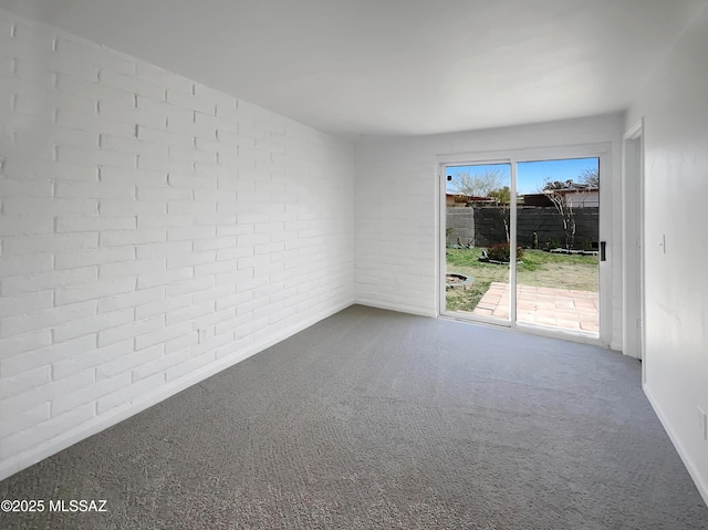 spare room with carpet and brick wall