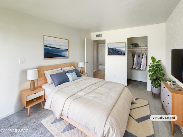 bedroom with a closet, visible vents, and light carpet