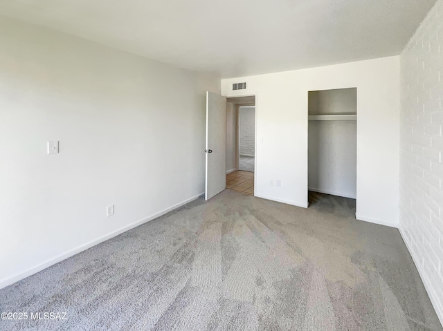 unfurnished bedroom with a closet, carpet, visible vents, and baseboards